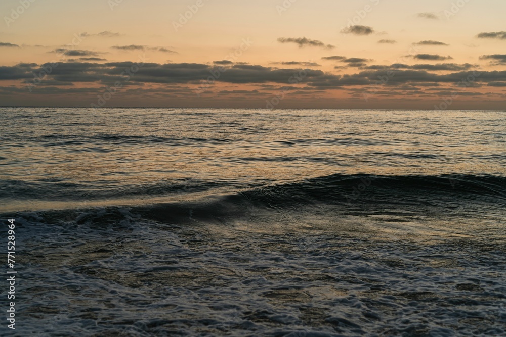 Obraz premium Surreal sunset over the ocean with a pristine sky.