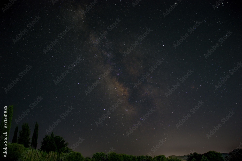 closeup of a tranquil long-exposure image of a starry night sky above a small stream closeup of a tranquil long-exposure image of a starry night sky above a small stream