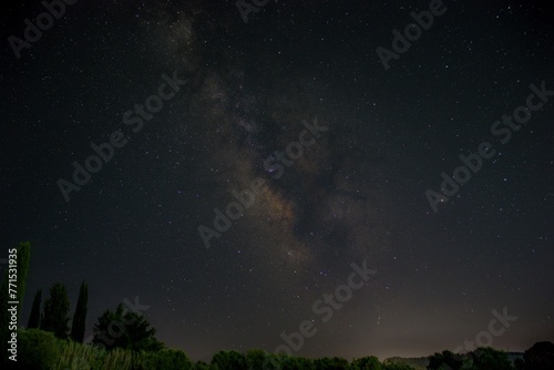 closeup of a tranquil long-exposure image of a starry night sky above a small stream