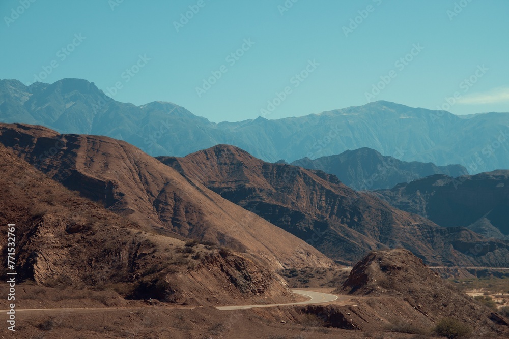 Naklejka premium Picturesque desert mountain landscape featuring a meandering road winding through its terrain