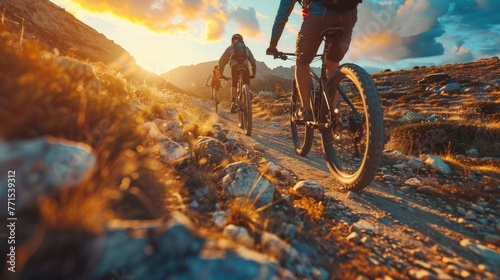 Low angle view of cross country bikers traveling in mountain landscape at sunset
