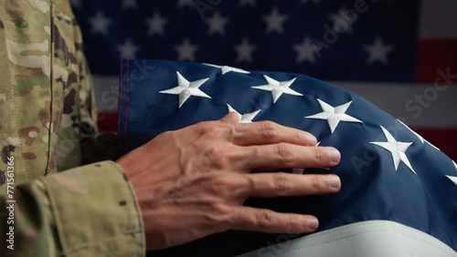 Hand of a Soldier touching stars of USA flag for the memorial Day 