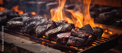 The flames dancing on the grill are cooking a variety of meats, emitting heat and gases into the air. The fire is fueled by wood, creating a smoky and flavorful cooking event photo