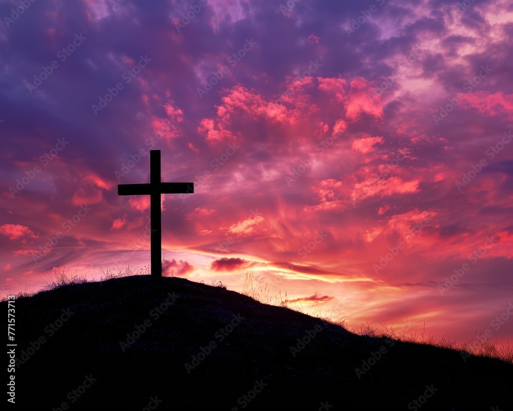 The dawn's first light casts a glow upon the Christian cross resting on the verdant hill.