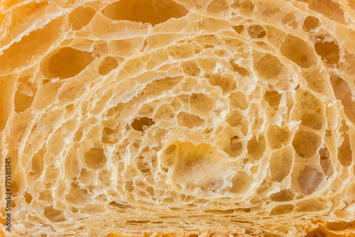 Macro shot of fresh croissant cut in a half. Baked croissant dough textured background