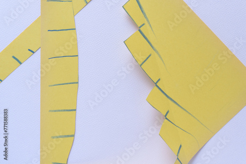 yellow paper with blue lines and jagged edges on blank paper with texture