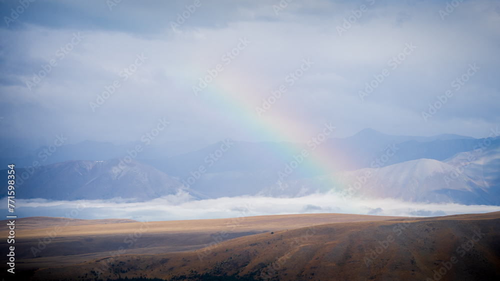 Rainbow arching over alpine landscape just after the storm, New Zealand