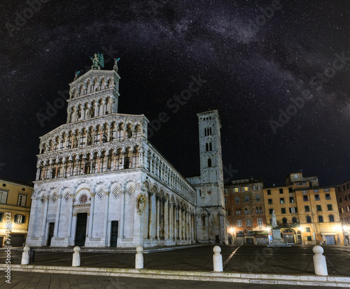 Lucca (Tuscany, central Italy) city night view with Milky Way stars sky. The San Michele in Foro (Roman Catholic basilica church). Facade build in 13th century. photo