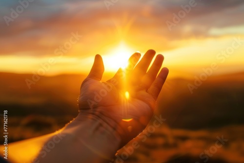 Hand reaching out for help in front of bright sunset sky