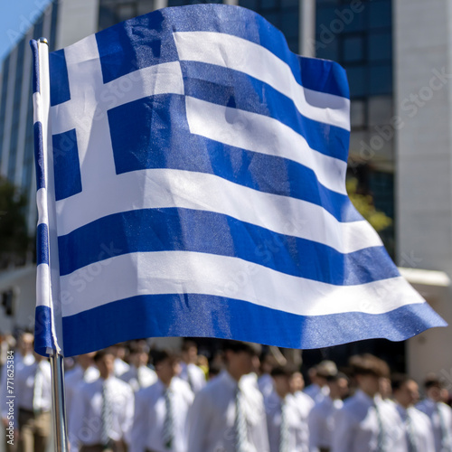Greek flag in front of school students marching on Greek Independence Day parade in Limassol, Cyprus