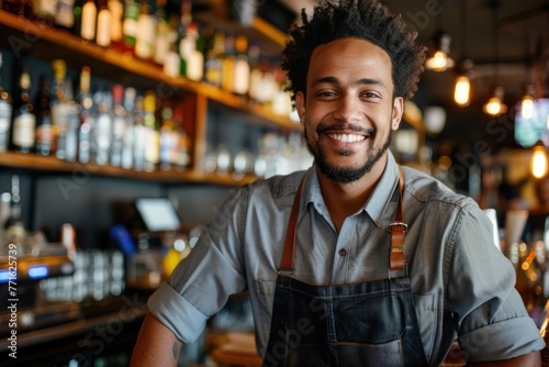 Smiling portrait of a young male bartender working in a bar photo