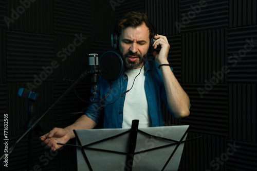 Male vocalist recording in sound booth
