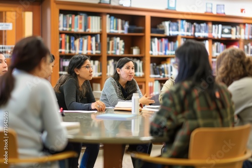 A group of individuals sitting around a table in a library, engaged in a focused discussion with key stakeholders
