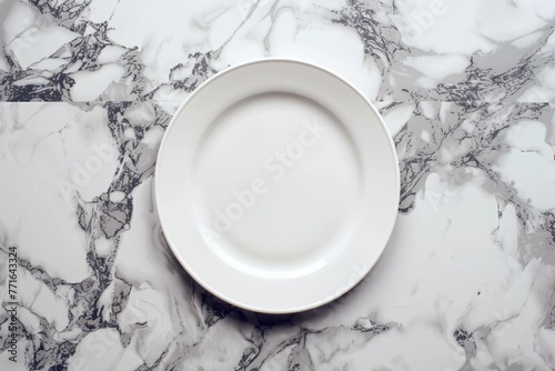 A top-down view of a white porcelain plate placed on a luxurious marble countertop