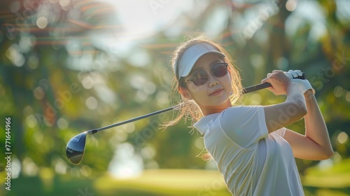 Beautiful professional woman golfer wearing sport wear in golf tournament on beautiful green course