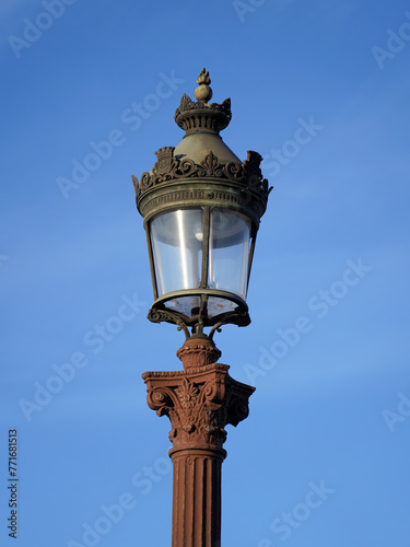 Parisian antique street lamp in Concorde Square on blue sky background