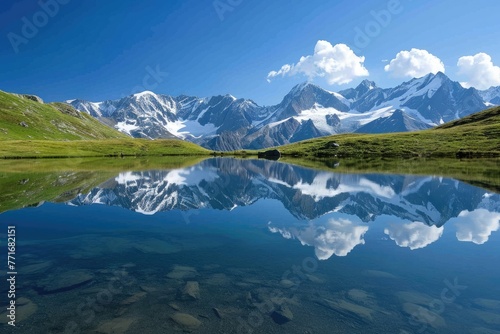 Pristine Alpine Lake Reflecting Snow Capped Peaks © SaroStock