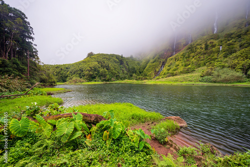 Azores scenic landscape, Flores island. Iconic lagoon with several waterfalls on a single rockface, flowing into lake Alagoinha. Best travel destination in Portugal, amazing vacations place. photo