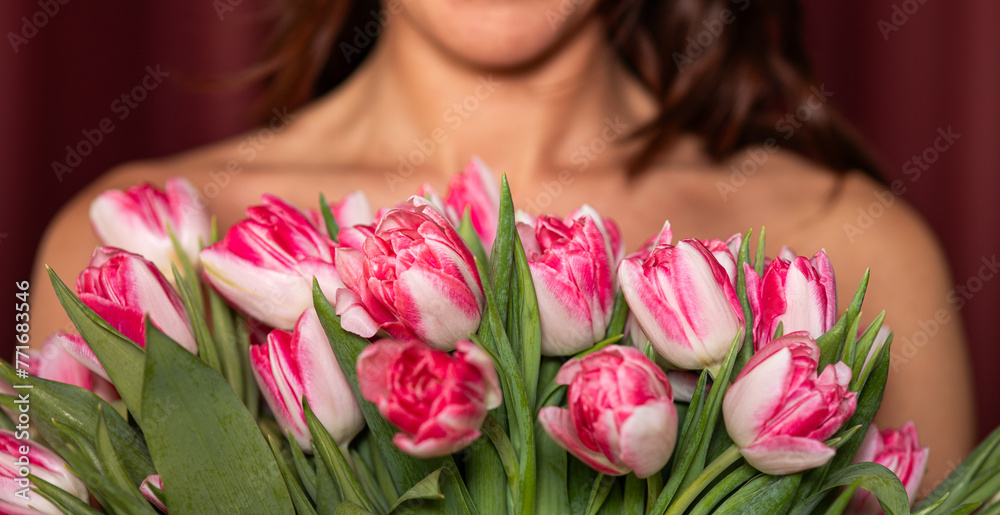 A woman clutches a bouquet of tulips to her chest