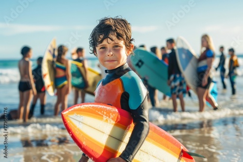 Young child with surfboard on beach looking at sea. Future surfer's anticipation. © olga_demina