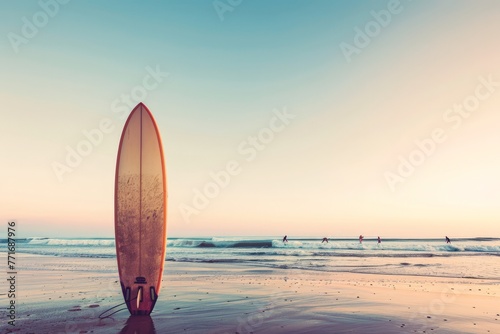 Surfboard standing on the beach at sunset. Ready to ride the evening waves. © olga_demina