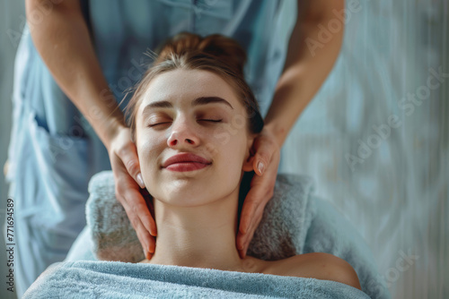 Ragazza rilassata mentre riceve un massaggio terapeutico professionale sul collo e sulle spalle photo