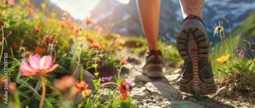 Close up of a female hiker's shoes walking on a mountain path with flowers