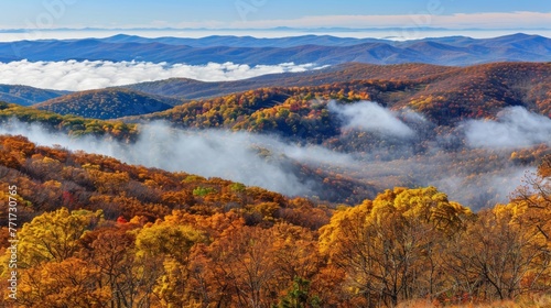  A picturesque scene of a mountain range during autumn, featuring clouds above and trees in the foreground