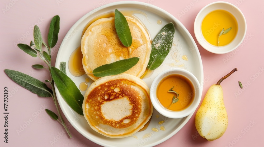  A white plate holds pancakes, a sauce bowl, and a pear on a pink background