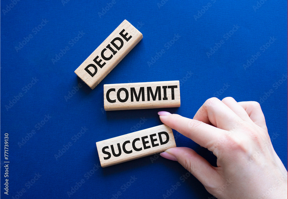 Decide Commit Succeed symbol. Concept words Decide Commit Succeed on wooden blocks. Businessman hand. Beautiful deep blue background. Business concept. Copy space. Decide Commit Succeed symbol. Concept words Decide Commit Succeed on wooden blocks. Businessman hand. Beautiful deep blue background. Business concept. Copy space.