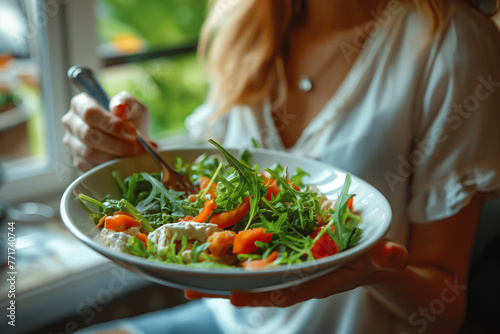 Close-up, a woman eats a healthy salad of green vegetables and tomatoes. Healthy food concept