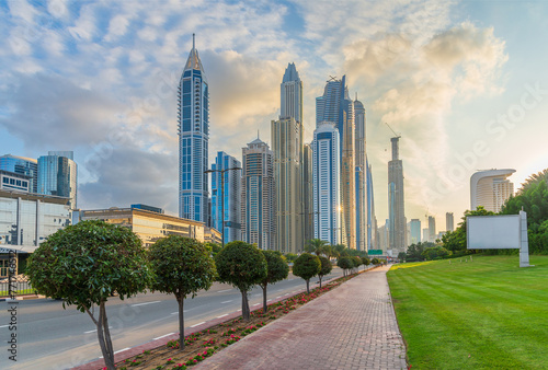Sunset in the Dubai Marina area. View of skyscrapers from the sidewalk