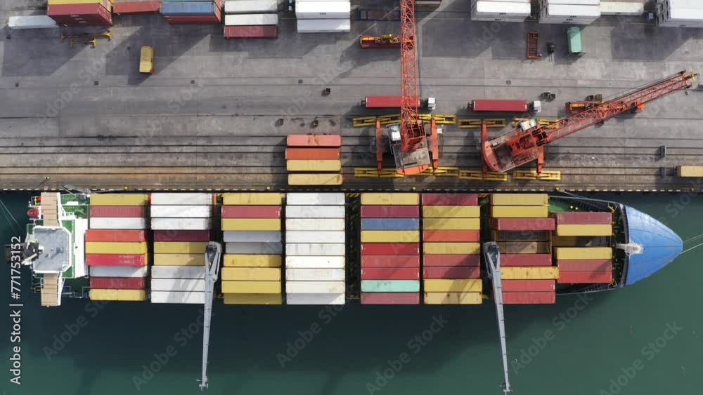 Top down aerial view of cargo ship loading containers. Showcases maritime shipping efficiency. Part of global distribution network.