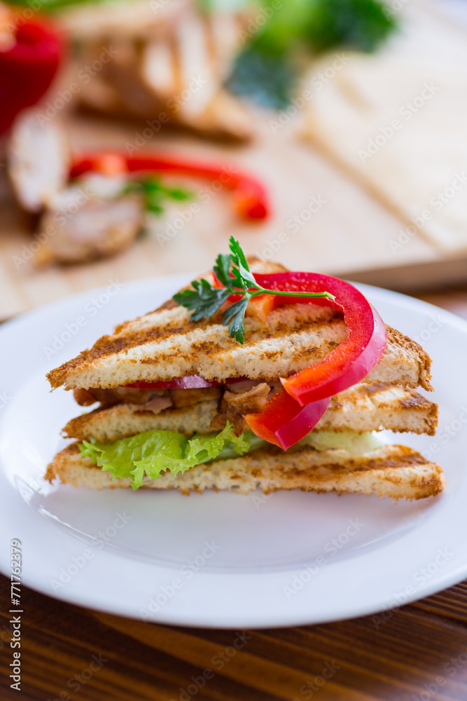 fried toast with chicken, salad, greens on a wooden table fried toast with chicken, salad, greens on a wooden table