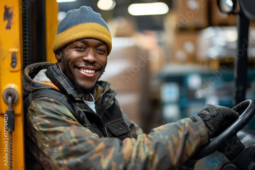 Portrait of a young African American warehouse worker driving a forklift. Smiling warehouse employee works in large warehouse distribution center.