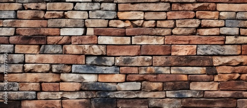 A close up of a brown brick wall with a pattern of rectangular bricks laid by a skilled bricklayer using mortar as a building material