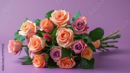 Bouquet of pink and peach roses on a purple background.