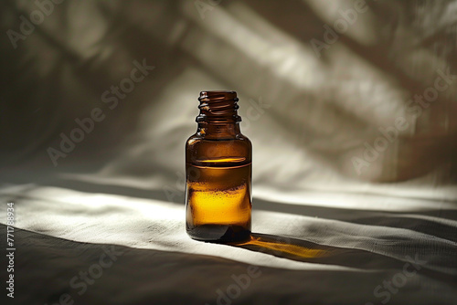 A brown bottle of aromatherapy essential oil on a table with sunlight and shadows © Madeleine Steinbach