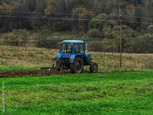 Mechanized plowing of land with the help of a tractor in autumn