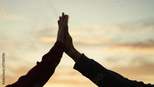 High five hands at sunset silhouette. Best friends buddies clapping each other palms in field park at dawn. Teamwork successfully completed business celebration rejoicing friendly feelings expression