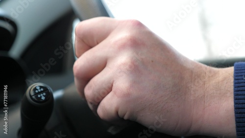 Male hand holding steering wheel driving car automobile road trip and freedom closeup. Man arm riding auto transportation vehicle speed movement highway route expressway traffic transport side view