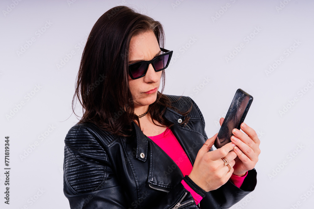 A frustrated young woman with a broken phone in her hands. White isolated background. Broken Gadget A frustrated young woman with a broken phone in her hands. White isolated background. Broken Gadget