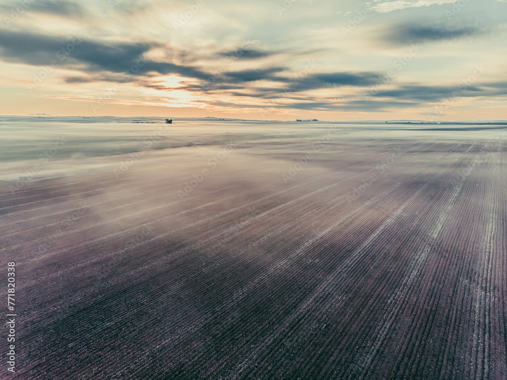 A field of land with a cloudy sky in the background A field of land with a cloudy sky in the background