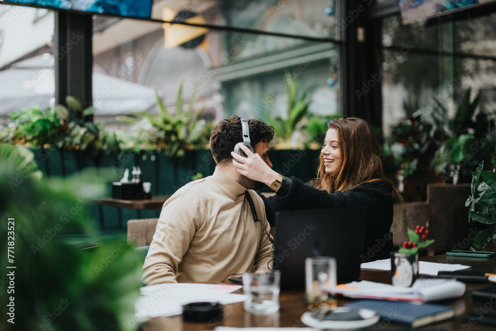A cheerful woman playfully adjusts a man's hair while enjoying a relaxed moment together at a cozy outdoor cafe, surrounded by greenery. A cheerful woman playfully adjusts a man's hair while enjoying a relaxed moment together at a cozy outdoor cafe, surrounded by greenery.