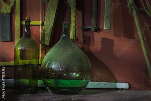 Green demijohns of old/antique and dusty glass, traditional Sicilian wine bottles, vintage carboys. photo