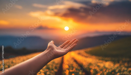 Hand reaching towards sunset sky, symbolizing hope, aspiration, and connection to nature. Perfect for inspirational concepts