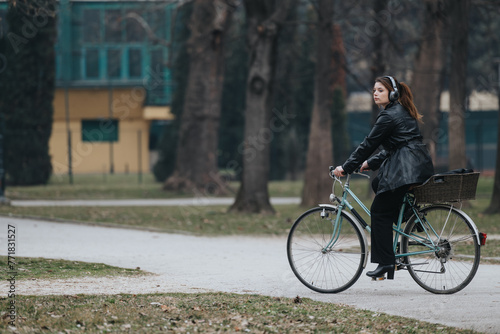 An elegant and confident young businesswoman enjoys a leisurely bike ride through a serene park setting.