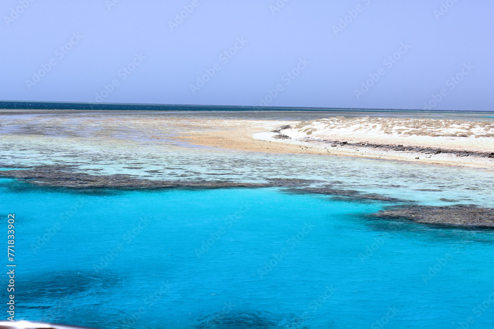 Obraz premium Captivating view of Egypt's Red Sea coral reef near Marsa Alam, Hamata Islands. Crystal-clear turquoise waters under a warm, sunny sky.