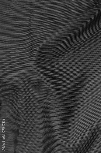 Black crumpled natural nylon fabric texture pattern detail, large detailed textured vertical creased textile swatch background macro closeup