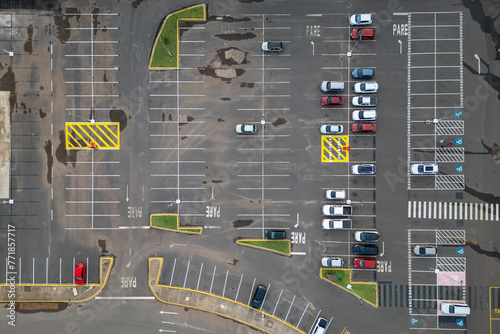 Foto Aerial view of expansive parking lot with cars parked, empty spaces, and designated spots for disabled and elderly individuals